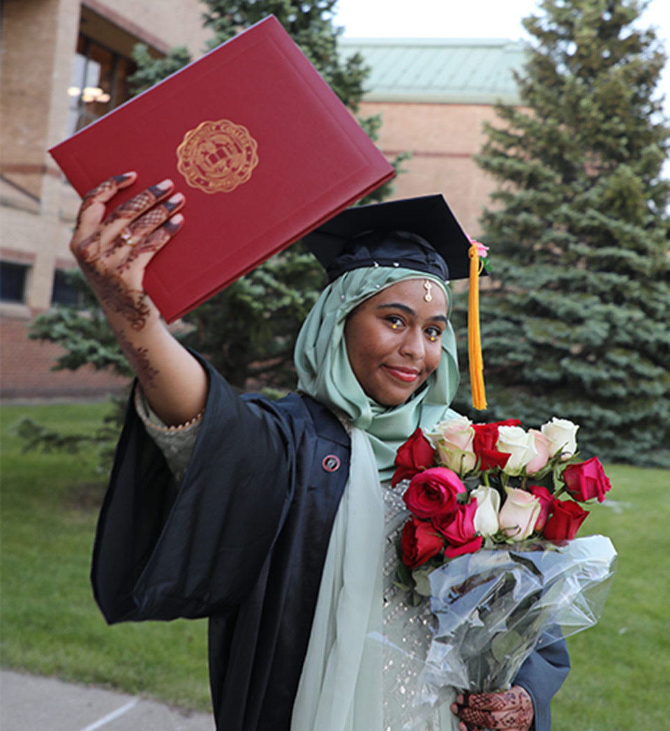 Student graduating holding diploma and flowers